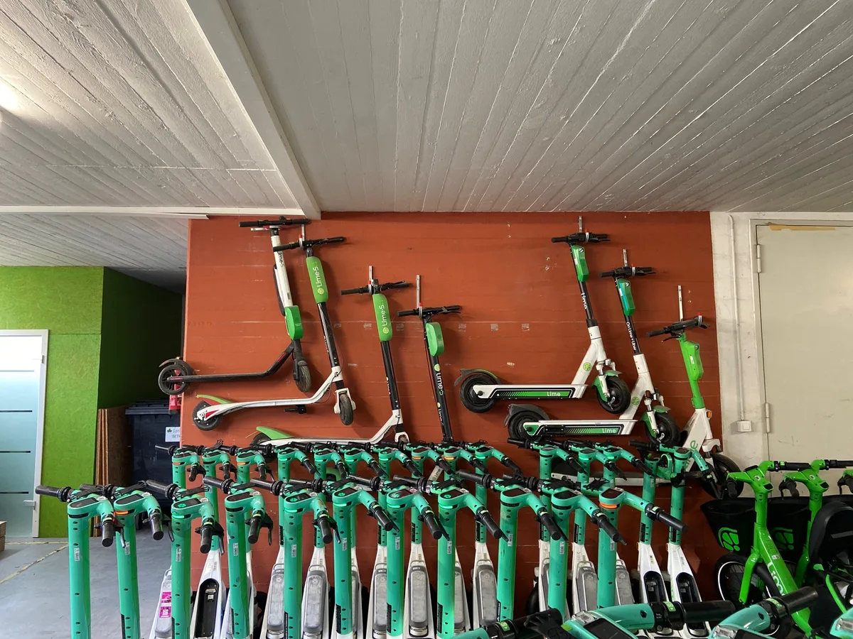 Alte Lime-Trottinetts hängen an der Wand.